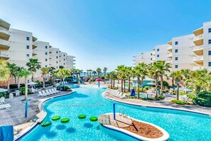 A swimming pool with multiple lanes, surrounded by palm trees and lounge chairs. - 2nd Floor Warm, Welcoming Condo At Waterscape Playground, 2 Hot Tubs (Fort Walton Beach)