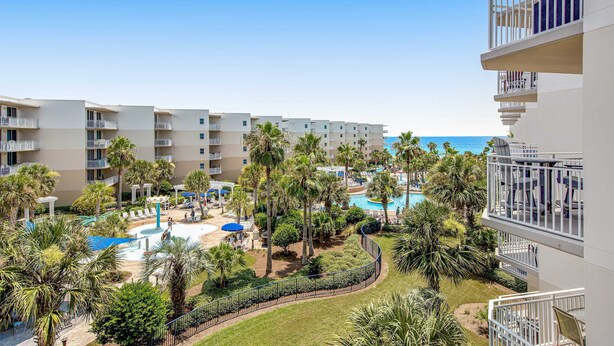 Een resort met meerdere gebouwen, een zwembad en palmbomen.