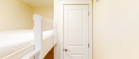A small room with a bunk bed and a door.