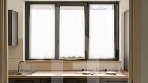 A kitchen with a window, a sink, and cabinets.