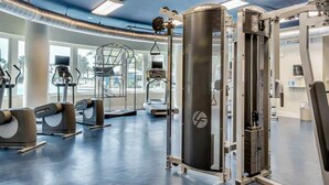 A gym with treadmills, elliptical machines, and weightlifting equipment. - 5th Floor Gulf-Front Condo w Free WiFi, Shared Hot Tub, Outdoor Pool, & More (Fort Walton Beach)