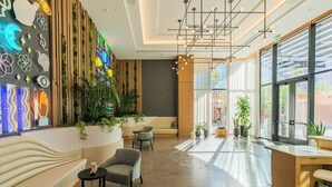 Un vestíbulo moderno con zona de estar, mostrador de recepción y un amplio ventanal con vistas al exterior.