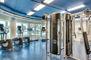 Ein Fitnessstudio mit verschiedenen Trainingsgeräten, darunter Laufbänder und Kraftgeräte.