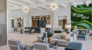 A spacious living area with a modern kitchen, dining area, and a green wall with 'Your Castle Awaits' text. - Landing | Incredible 2BD, Yoga Studio, Gym (Four Corners)