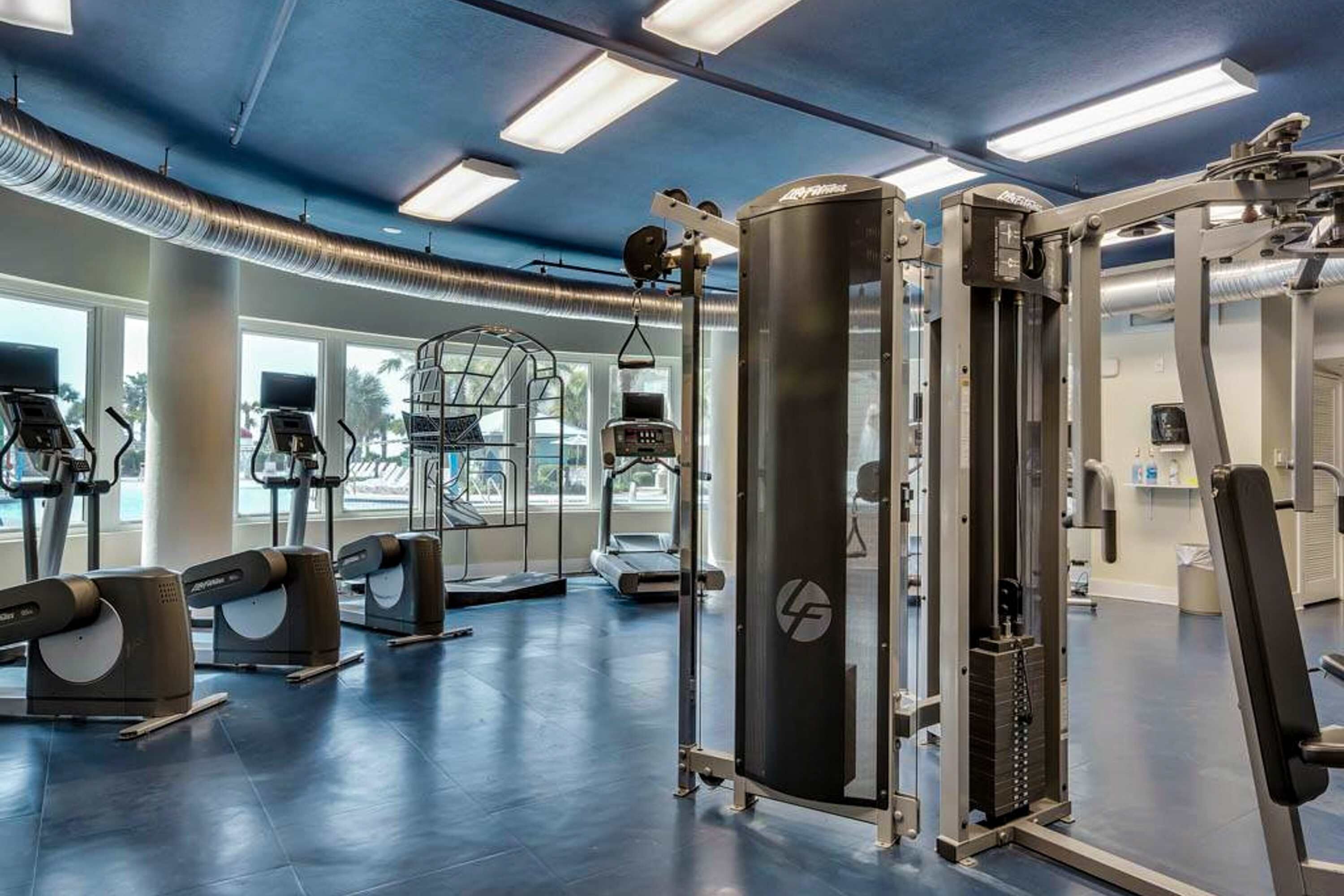 A gym with treadmills, weight machines, and a squat rack.