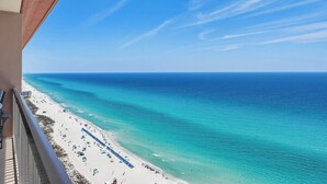 A beach view from a balcony with a clear sky and calm sea. - 25th-floor, waterfront condo with picturesque views, pools & fitness room (Panama City Beach)