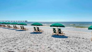 A beach with rows of green umbrellas and lounge chairs facing the ocean. - Spacious Ground-Floor Condo At Waterscape 490 Feet Of Private Beach (Fort Walton Beach)