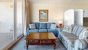 A living room with a sofa, a coffee table, and a painting on the wall. - 6th Floor Welcoming Condo At Waterscape Children's Playground, 2 Hot Tubs (Fort Walton Beach)