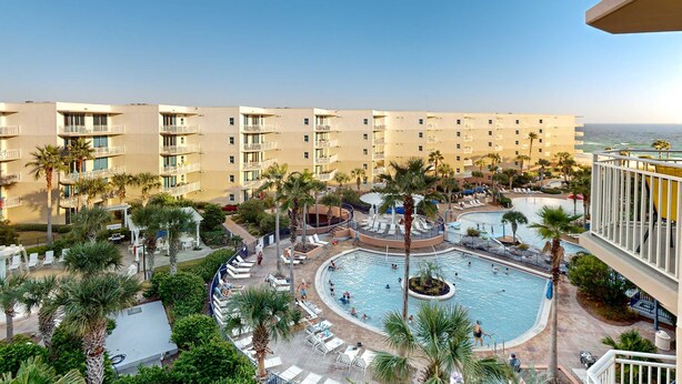 A resort with a central pool, palm trees, and a view of the ocean. - 6th Floor Welcoming Condo At Waterscape Children's Playground, 2 Hot Tubs (Fort Walton Beach)