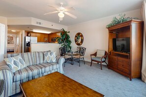 A living room with a sofa, coffee table, dining table, chairs, and a TV cabinet. - 6th Floor Welcoming Condo At Waterscape Children's Playground, 2 Hot Tubs (Fort Walton Beach)