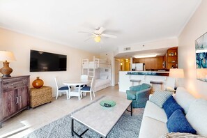 A modern living room with a sofa, coffee table, and a TV mounted on the wall. - Condo On Okaloosa Island Children's Playground, 2 Hot Tubs (Fort Walton Beach)