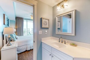 A modern bathroom with a large mirror, white vanity, and a view of the balcony. - Elegant, Decorated Condo At Waterscape Waterfall, Lazy River (Fort Walton Beach)