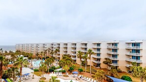 A hotel with multiple floors, a pool area, and palm trees. - Elegant, Decorated Condo At Waterscape Waterfall, Lazy River (Fort Walton Beach)