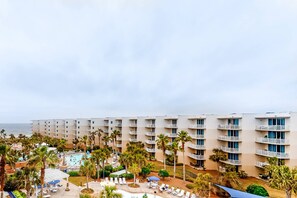 A hotel with multiple floors, a pool area, and palm trees. - Elegant, Decorated Condo At Waterscape Waterfall, Lazy River (Fort Walton Beach)