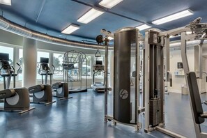Ett gym med löpband, styrketräningsmaskiner och en stor träningsboll.