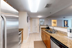 A modern kitchen with stainless steel appliances, granite countertops, and a dishwasher. - 3rd Floor Coastal Condo On Okaloosa Island Waterfall, Lazy River (Fort Walton Beach)