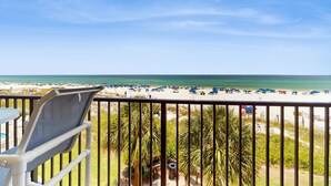 Un balcon avec vue sur une plage et l’océan.
