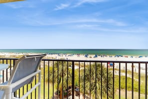 A balcony with a view of a beach and ocean. - Lovely beachfront condo with water views from private balcony + shared pool (Miramar Beach)