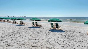 A beach with rows of green umbrellas and lounge chairs. - 6th Floor Welcoming Condo At Waterscape 490 Feet Of Private Beach (Fort Walton Beach)