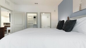 Ein Schlafzimmer mit einem großen Bett, einem Kleiderschrank und einem Schreibtisch.
