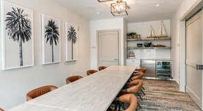 A dining area with a long table, brown chairs, and framed artwork on the wall. - Landing | Chic 2BD, Gym, Clubhouse (Apopka)