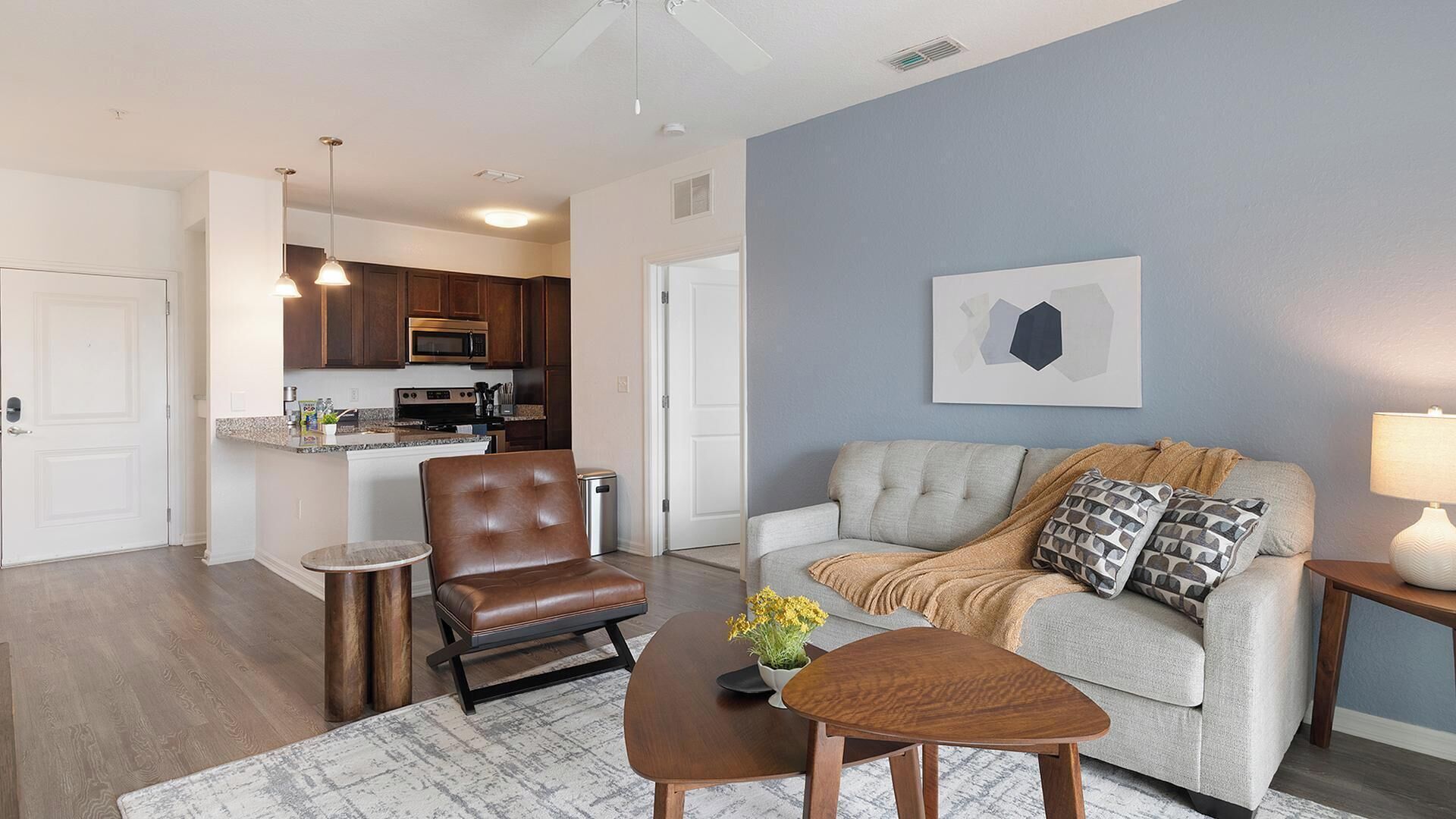 A living room with a sofa, a coffee table, a leather chair, and a small side table.