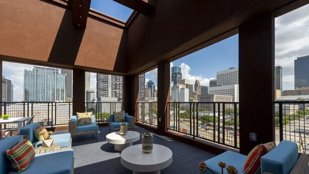 Eine Dachterrasse mit Sitzgelegenheiten und Blick auf die Stadtlandschaft.