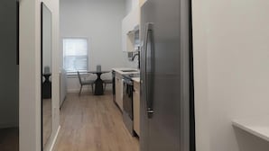 Une cuisine compacte comprenant un réfrigérateur, un évier et un coin repas avec des chaises et une table.