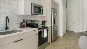 Een moderne keuken met een magnetron, oven en koelkast.