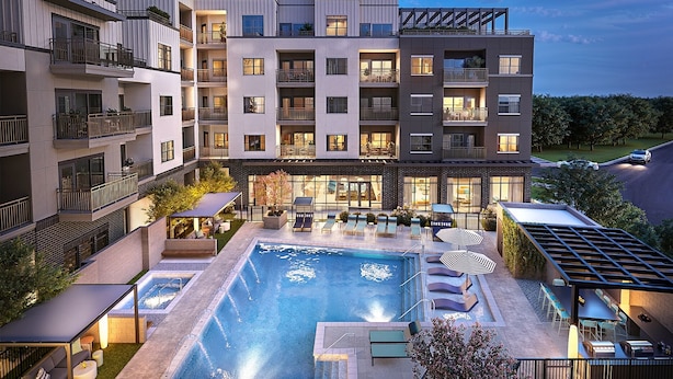 A multi-story hotel with a rooftop pool, outdoor seating, and a well-lit entrance. - Landing | Stunning 2BD, Gym, Game Room (Chapel Hill)