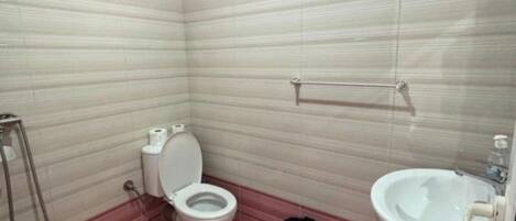 A bathroom with a toilet, bidet, and sink.