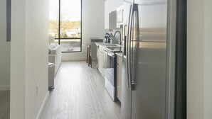 Una cocina moderna con un ventanal grande, lavavajillas y refrigerador.