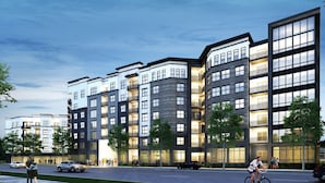 Un edificio residencial de varios pisos con balcones, ventanas amplias y un diseño arquitectónico moderno.