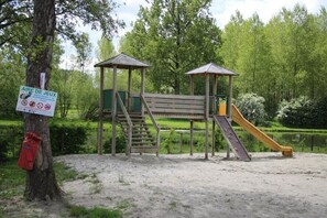 Ein Spielplatz mit einer Holzkonstruktion, einer Rutsche und einer Treppe.