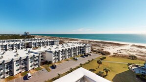 Hotel amb vistes a la platja i a l'oceà, amb diversos balcons i zona d'aparcament.