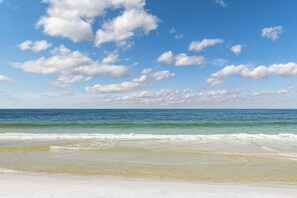 A beach with clear skies and ocean waves. - Plantation Dunes condo with Gulf views, pool, hot tubs & gym - walk to beach (Fort Morgan)