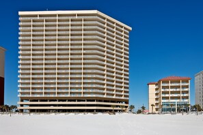 A multi-story hotel with a flat facade, numerous balconies, and a clear blue sky. - Waterfront home with a private deck, gas grill, WiFi, & central AC (Gulf Shores)
