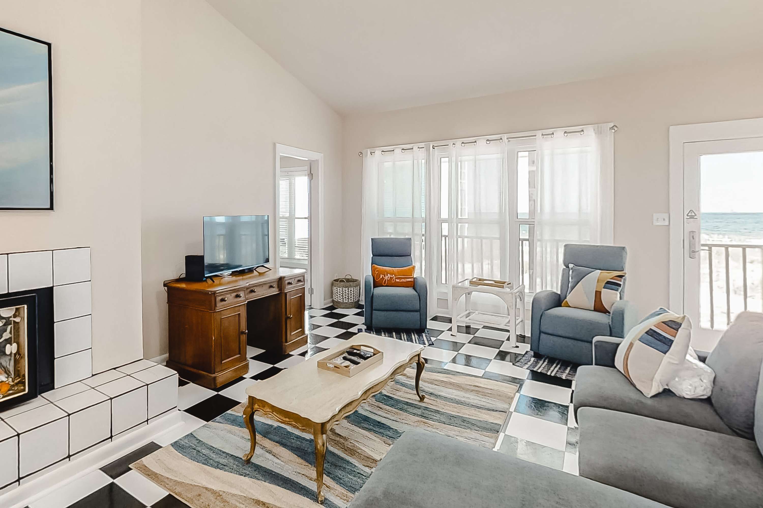 A living room with a checkered floor, a television, a sofa, and a chair.