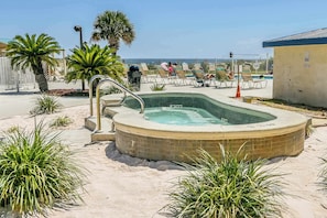 A hot tub surrounded by sand, palm trees, and lounge chairs. - Contemporary beachside escape with gym, & pools (Fort Morgan)