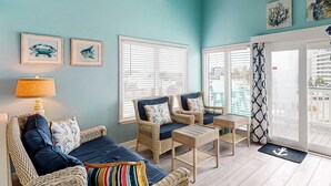A room with wicker furniture, a lamp, and framed artwork on the walls. - Third-floor condo with balcony, close beach access, pools, hot tubs & tennis (Fort Morgan)