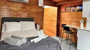 Une pièce aménagée comme un chalet en bois, avec un lit, un bureau et une chaise.