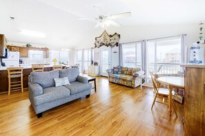A spacious living area with a sofa, a dining table, and a ceiling fan. - Dog-friendly home near the beach with grill, central AC & balcony (Fort Morgan)