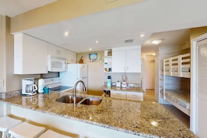 A modern kitchen with granite countertops, stainless steel appliances, and white cabinetry. - Plantation Palms #6205 with Resort Pools, Hot Tubs & Tennis, Steps to Beach (Fort Morgan)