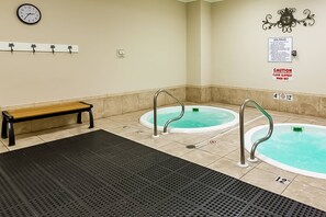 A spa area with two hot tubs, a bench, and safety signs. - Plantation Palms #6205 with Resort Pools, Hot Tubs & Tennis, Steps to Beach (Fort Morgan)