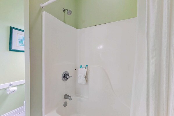 A shower with a white tub, a towel rack, and a framed picture on the wall. - Great Duplex with large decks and large shared pool (Fort Morgan)