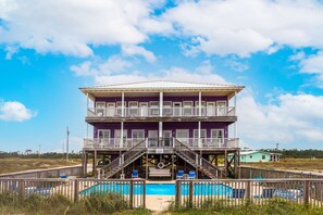 A two-story building with a pool, a balcony, and a lifeguard tower. - Great Duplex with large decks and large shared pool (Fort Morgan)