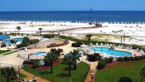 Ein Resort mit mehreren Swimmingpools, einem Strandbereich und Meerblick.