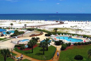 Ein Resort mit mehreren Swimmingpools, einem Strandbereich und Meerblick.
