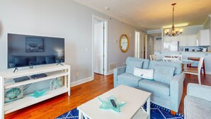 Una sala de estar moderna con televisor, sofá y mesa de centro.