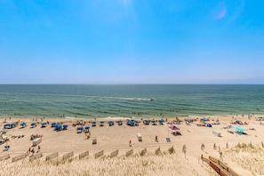A beach with umbrellas and people, a wooden fence, and a clear sky. - Beautiful Gulf Shores Home w/Shared Pool, Hot Tub, and Sauna + Free WiFi (Gulf Shores)